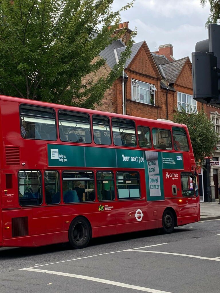 Photo of a bus in London with the campaign graphic - your next poo could beat bowel cancer