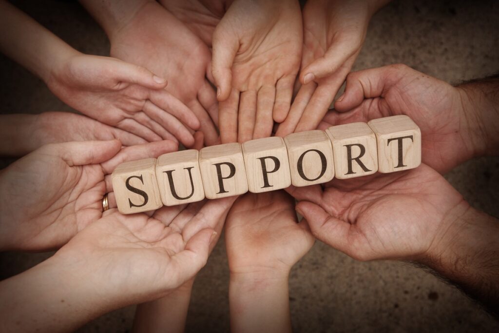 A close up of wooden building blocks spelling out Support