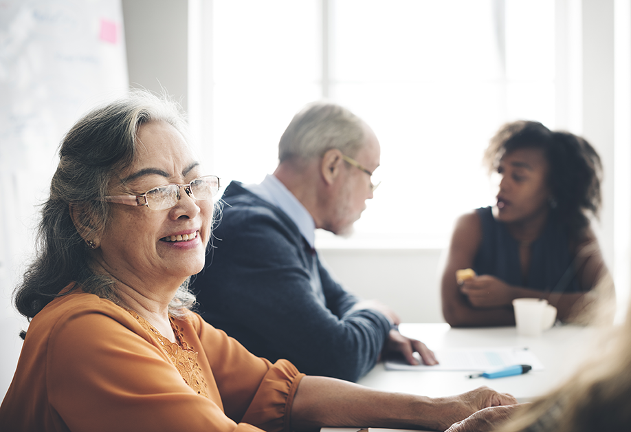 Two senior people and a younger person engaging in conversation