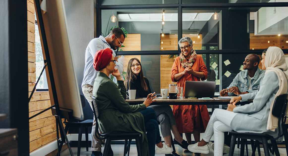 A mixed-sex, mixed-race, multi-generational gathering of people around a table.