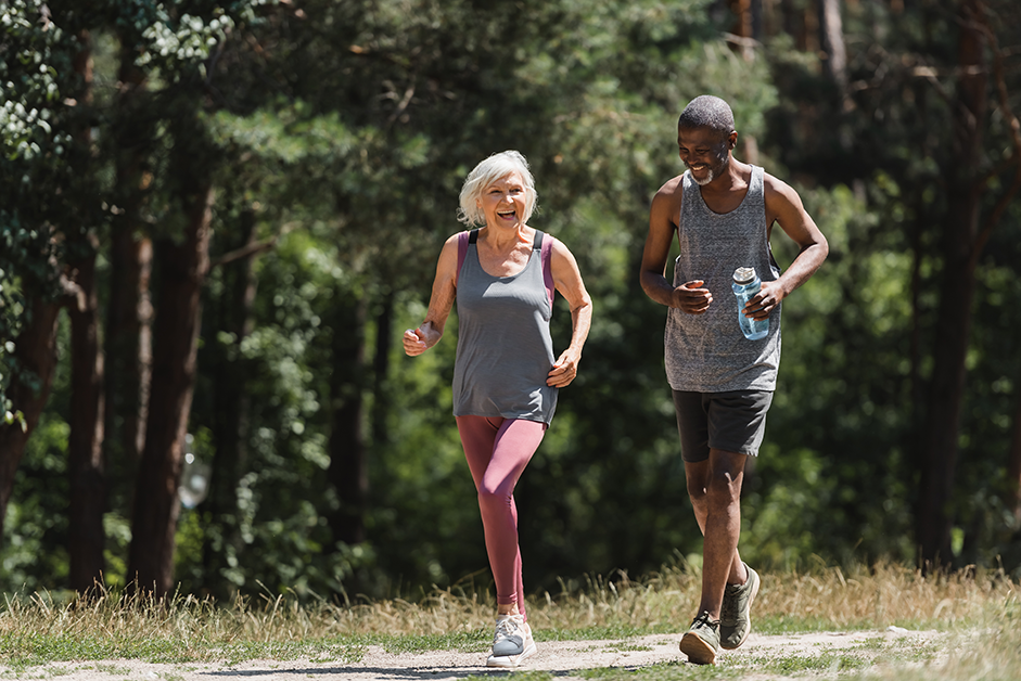 Two senior people jogging, one with a water bottle