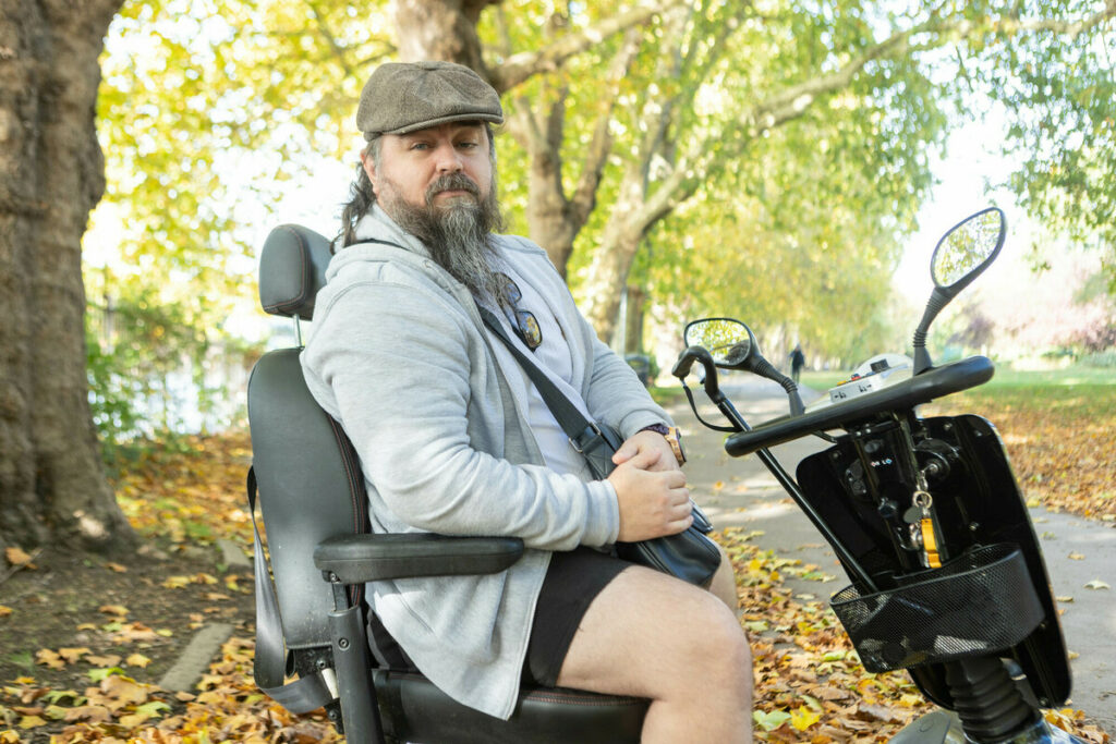 A person sitting on a motorised wheelchair.