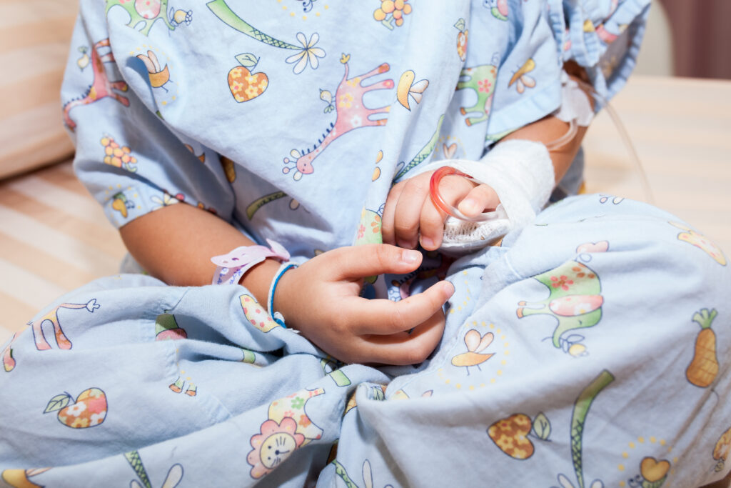 child in hospital gown with bandaged arm