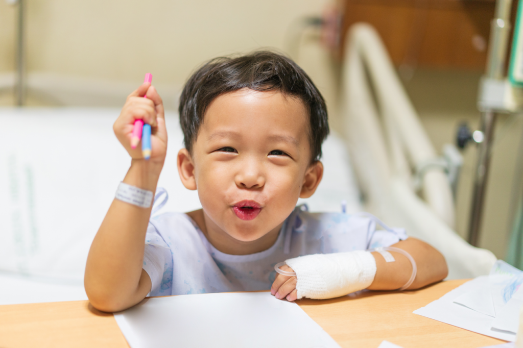 Child in hospital bed drawing a picture