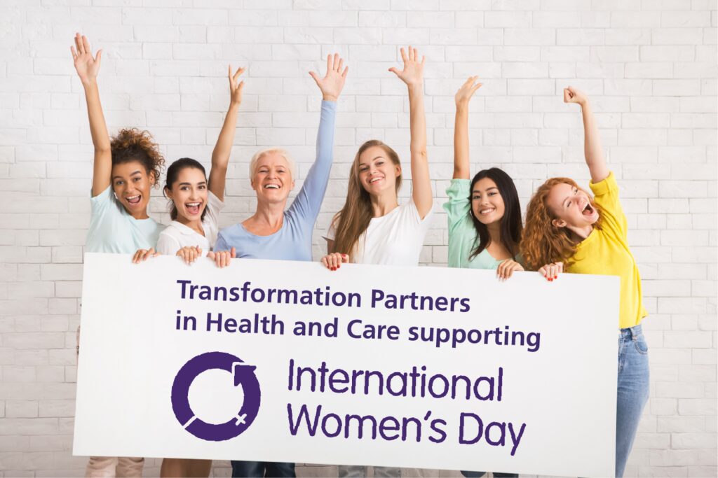 A diverse group of women holding a sign displaying the words "Transformation Partners in Health and Care supporting International Women's Day"