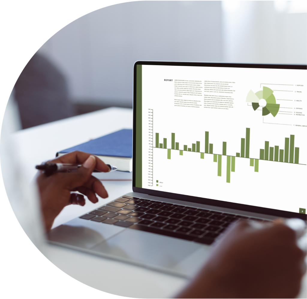 A laptop open with a report displayed on screen, with charts in shades of green