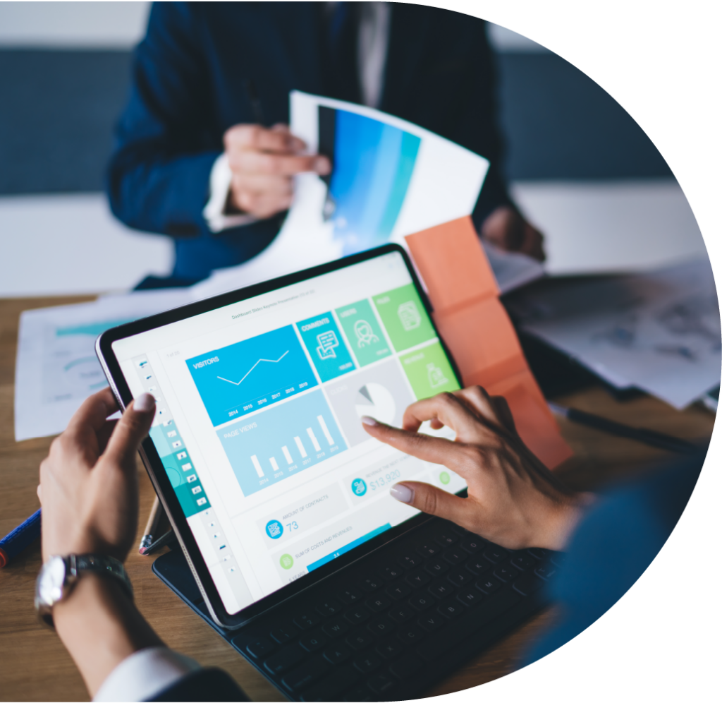 Two professionals, one looking at a tablet screen which is showing charts