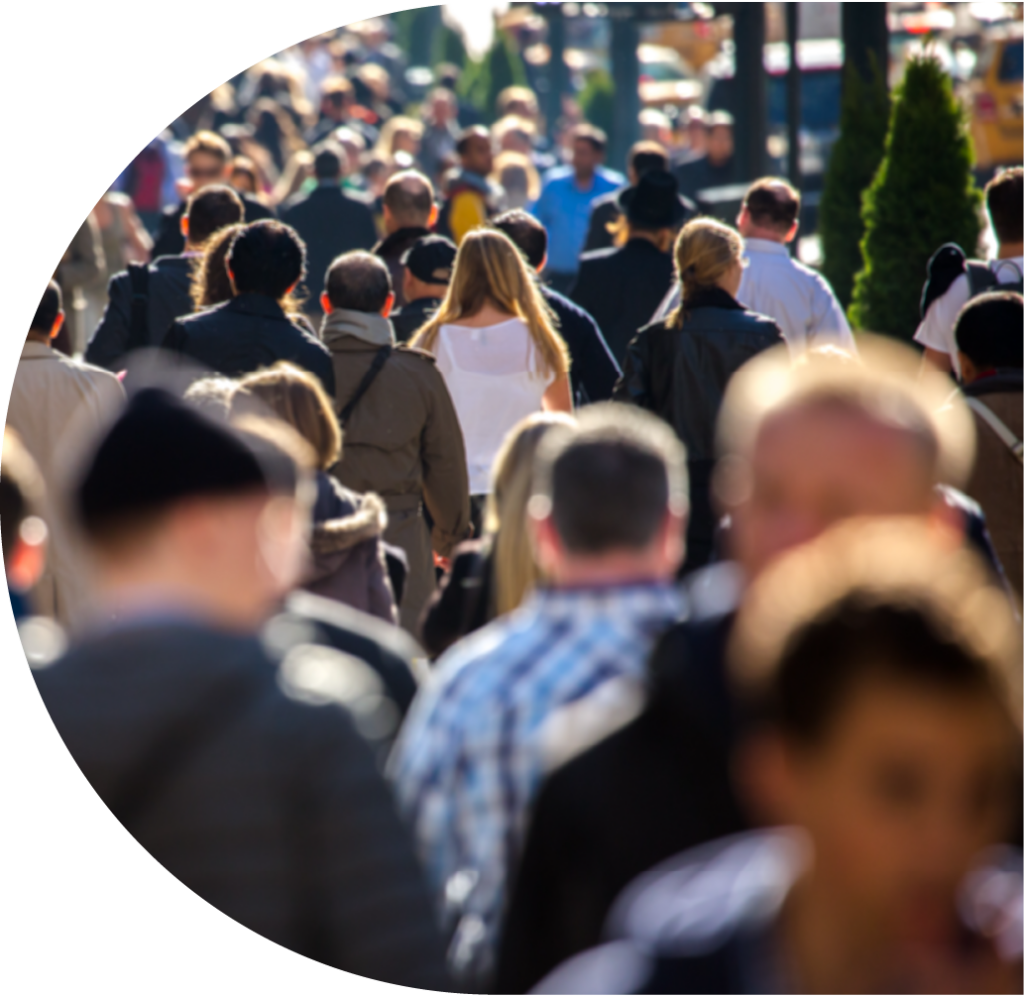 A sunny but cold streetscape with crowds of people in coats and hats