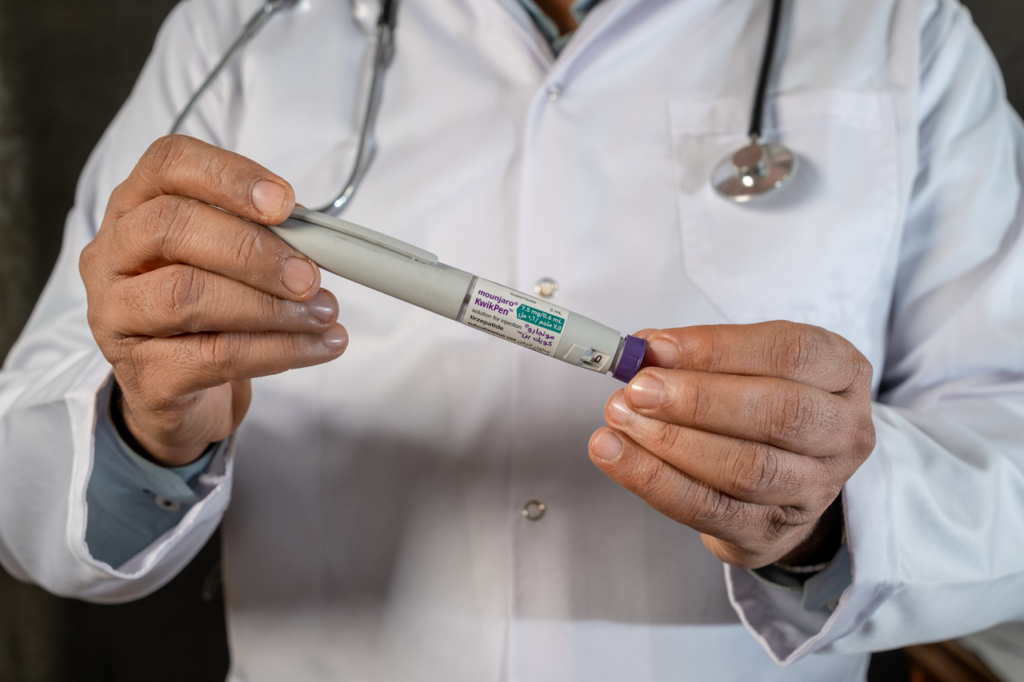A medical practitioner holding a Mounjaro pen