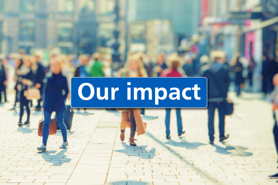 A streetscape with multiple people and the words 'our impact'