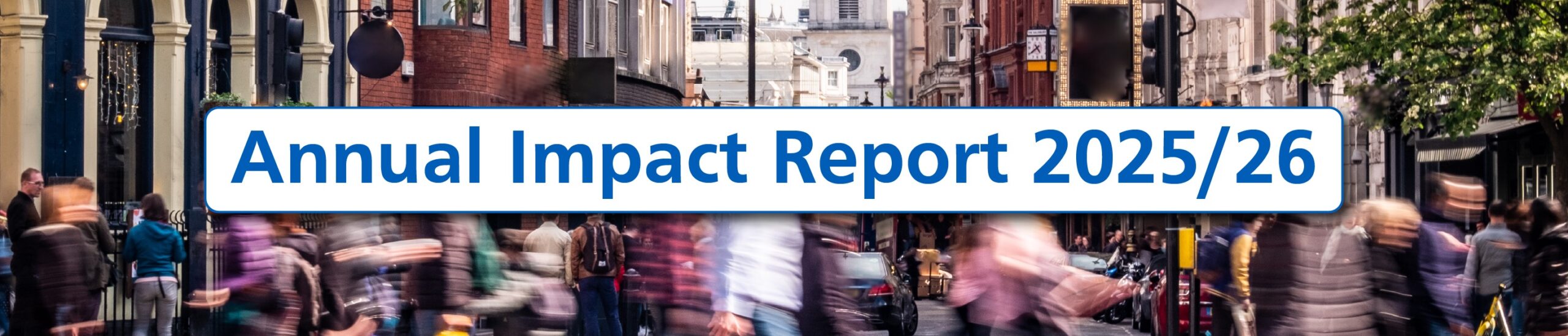 A wide banner image showing a busy London street with blurred pedestrians crossing in the foreground and historic city buildings lining both sides. The spire of St Martin-in-the-Fields rises in the distance beneath a cloudy sky. A large white rounded rectangle with a blue border overlays the centre, displaying the title ‘Annual Impact Report 2025/26’ in bold blue text.