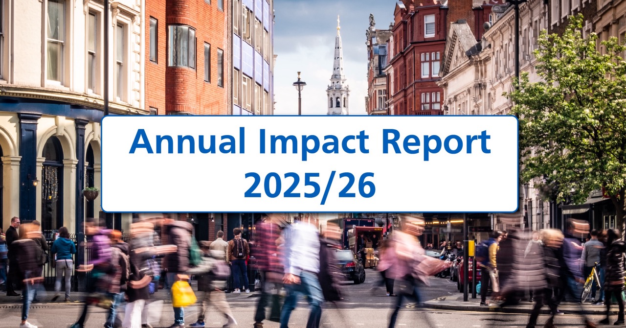 A wide banner image showing a busy London street with blurred pedestrians crossing in the foreground and historic city buildings lining both sides. The spire of St Martin-in-the-Fields rises in the distance beneath a cloudy sky. A large white rounded rectangle with a blue border overlays the centre, displaying the title ‘Annual Impact Report 2025/26’ in bold blue text.